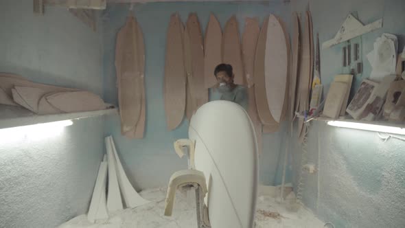 Artisan Sanding Edges of Surfboard alt