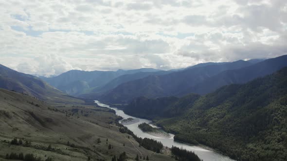 River Katun between mountains of Ak-Kem valley under white clouds in Altai