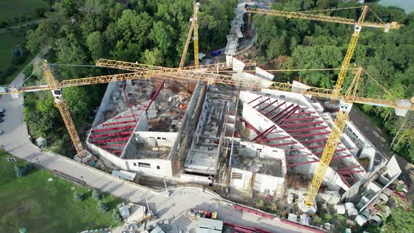 Aerial View Construction of a New Building with High Tower Cranes in Green Area alt