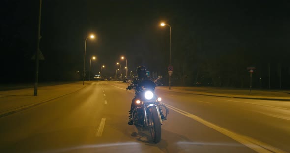 Motorcyclist is Riding on City Streets at Night