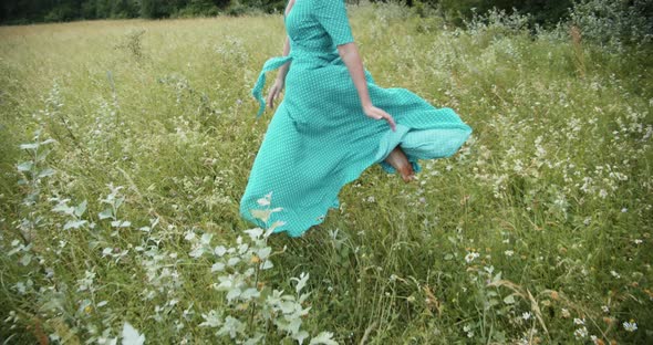 A Girl In A Long Dress Runs Across A Green Meadow alt