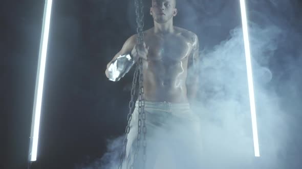 Sexy Man Dancing with Chains in Smoke