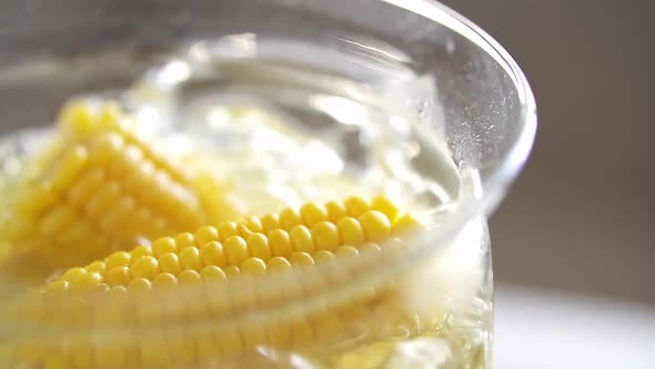 Ripe Corn Cobs In Boiling Water. Organic Yellow Corn In Glass Saucepan With Boiling Water. Cooking alt