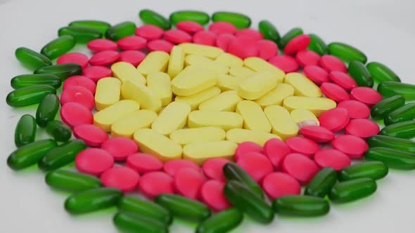 Rotating shot of colorful tablets placed over a white background alt