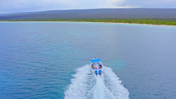 Tourists on motorboat sailing in turquoise Caribbean sea. Bahia de las Aguilas. Aerial alt