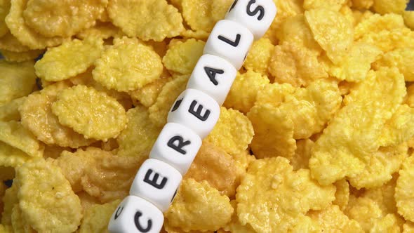 Crispy corn flakes rotating close up, dry healthy breakfast. Honey cornflakes for healthy cereal alt