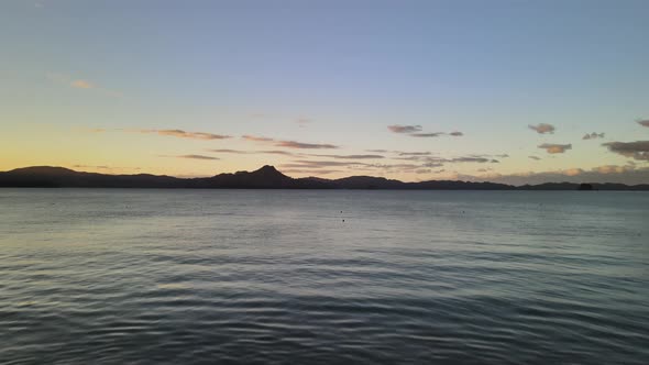Cinematic drone flight low above the water flying through the Coromandel Peninsula of New Zealand alt