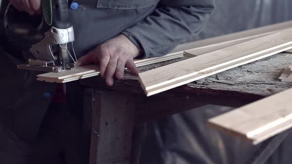 Man Sawing Wooden Plank with Jigsaw at Construction Site alt