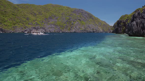 Tourist Island Hopping Boat in Ocean Strait with Rippled Surface. Matinloc Island. Tour C. Bacuit alt
