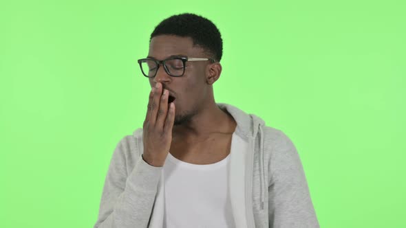 African Man Yawning on Green Background alt