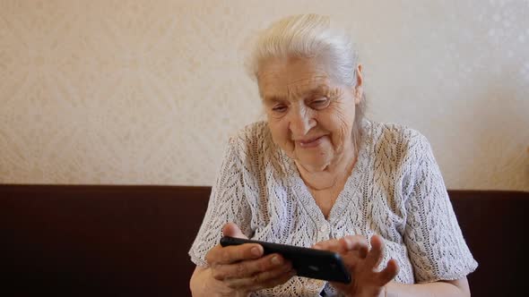Slow Motion Portrait of Happy Old Woman Using Smartphone and Smiling