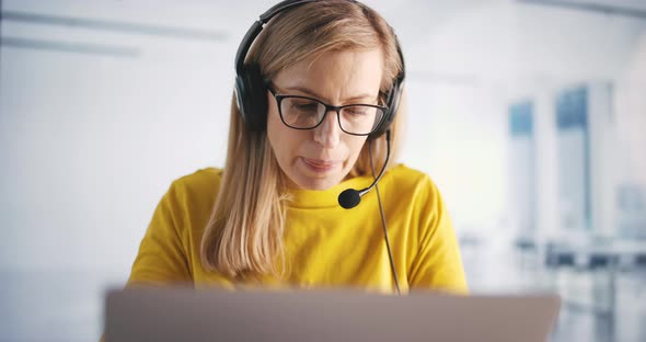 Woman in Headphones in Call Center