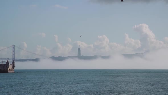 Birds flying over river, towards monument and bridge alt