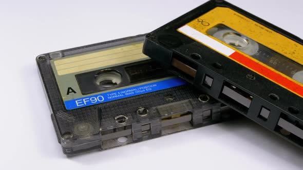Two Vintage Audio Cassette Rotates on White Background alt