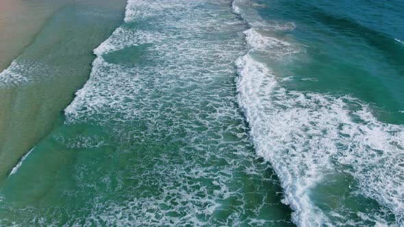 Nature seascape turquoise sea waves breaking on sandy beautiful foam,footage drone.Top view.