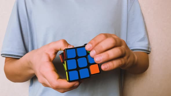 The Video Shows Hands and a Rubik's Cube in Closeup One Blue Side of Which is Collected and Shown to