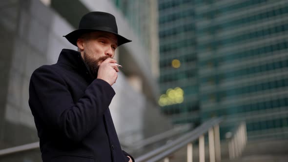 Spy or Undercover Policeman is Smoking Cigarette Outdoors in City and Stalking Someone alt