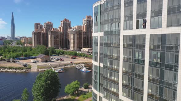 Aerial Drone static Shot of a building window cleaner with the Okonomiyaki structure in the backgrou alt