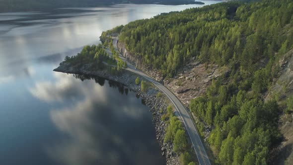 Flying Over Road with Car and Kroderen Lake Shore in Norway. Aerial Shot. Green Mountain with Trees alt