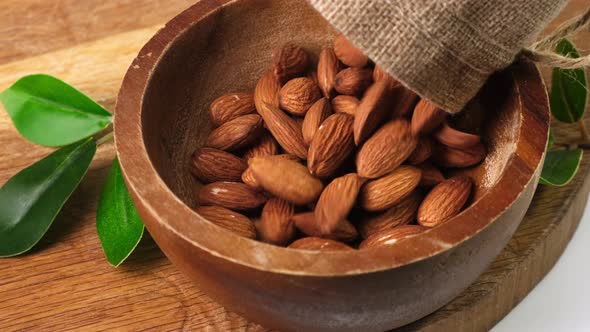 Almond Nuts to pour In Wooden Bowl. Healthy Food Concept