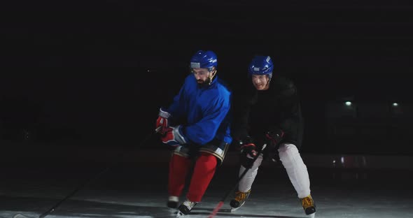 Two Man Playing Hockey on Ice Rink. Hockey Two Hockey Players Fighting for Puck. STEADICAM SHOT alt