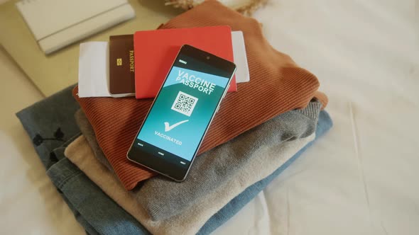 closeup asian female traveller hand arrange cloth stuffs passport smartphone alt