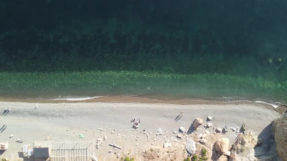 Aerial View From Above on Calm Azure Sea and Volcanic Rocky Shores alt