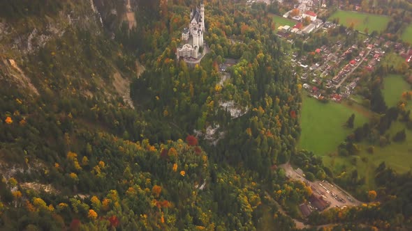 AERIAL: View of Neuschwanstein Castle in Forest,Mountains, Summer, Foggy, Colourful  alt