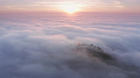 Aerial Above Pink Clouds Above Mountain Top on Magical Golden Sunrise, USA alt