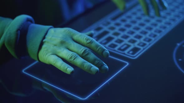Closeup of a Hacker's Hands Runs His Fingers Over the Touchpad