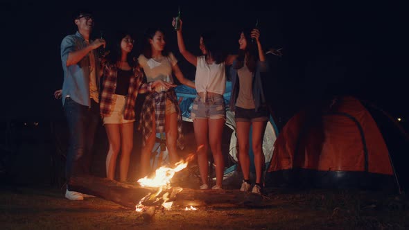 Group of Asia best friends dancing and drinking have fun salute toast of bottle beer at night. alt