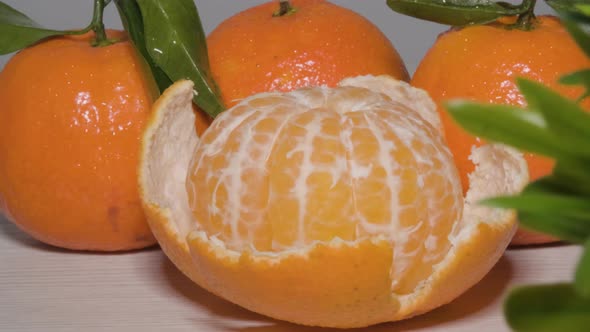 Close up shot rotating around a Kitchen table to reveal a half peeled ripe Mandarin orange, a sweet alt
