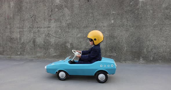 Funny businessman driving pedal car outdoor