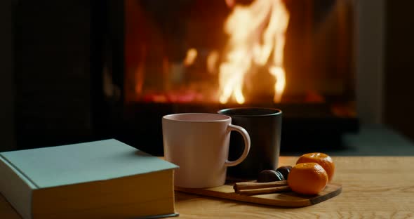 Cozy Autumn or Winter Mood with Fireplace Hot Tea Book and Tangerines