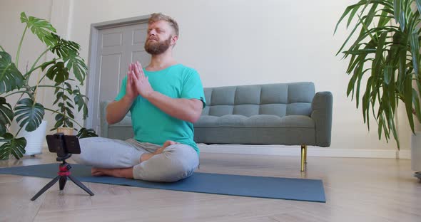 Middleaged Man Picking Up an Online Workout Guide for His Home Workout alt