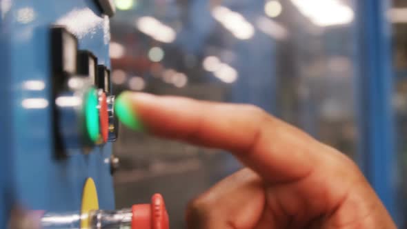 Worker checking machine next to production line alt