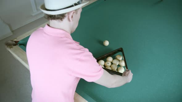 Playing Billiards a Man in a Tshirt Collects Balls in a Triangle alt