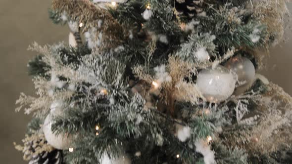 Closeup of Christmas Tree Decorated with Balls, Pine Cones, Garland and Pompons.