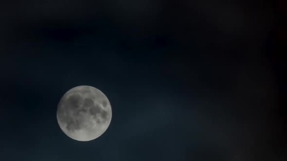 Timelapse  Moon Rising Against Black Sky with Moving Clouds at Night