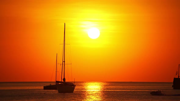 Sail boat in tropical sea at beautiful sunset or sunrise sky with Reflected sun on water surface alt