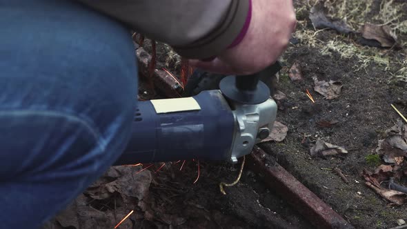 Man's Hands are Cutting the Old Destroyed Metal Structure with a Grinder alt