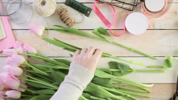 Time-lapse. Step by step. Florist wrapping pink tulips in bouquet alt
