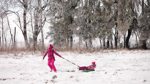 Young Mother and Little Daughter on the Snow