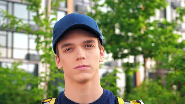Close Up Serious Young Man Courier Delivery with Thermal Backpack Looking Camera alt