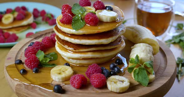 Pancakes are Served with Raspberries Banana Blueberry and Mint Leaf alt