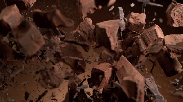 Super Slow Motion Shot of Raw Chocolate Chunks and Cocoa Powder after Being Exploded alt
