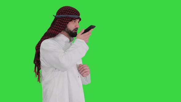 Arabian Businessman Recording Voice Message or Using Voice Digital Helper on a Green Screen, Chroma alt