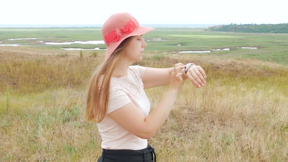 Walking girl using smartwatch outdoor. Young woman talking on vdeo call in smartphone with internet alt