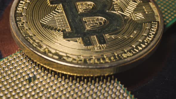 Golden Coin with Bitcoin Symbol on a Mainboard alt