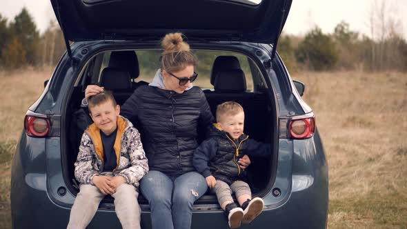 Family Mother And Child Boys Leisure. Son Boys Sitting In Car.  Kid Having Fun. Carefree Mom Sons. alt